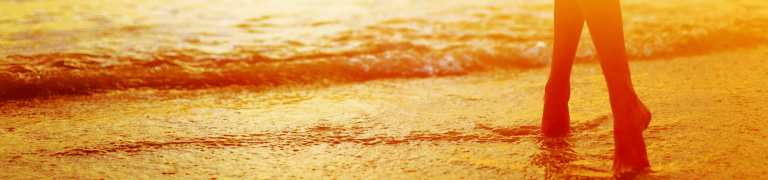 femme avec les pieds dans la mer