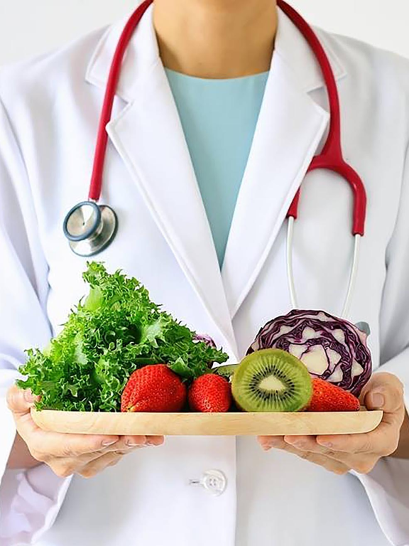 Nutritionniste avec un plateau de fruits et légumes dans les mains