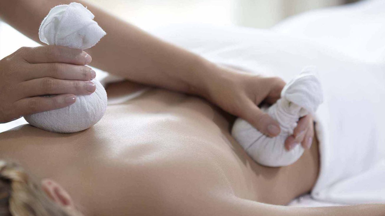 Application d'un soin cataplasmes algués sur le dos d'une femme