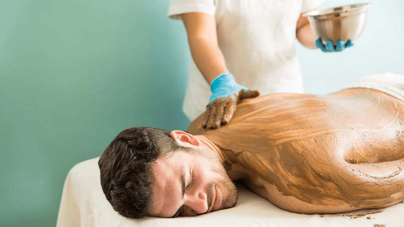 Homme durant un enveloppement de miel et karité sur lit hydrosensoriel