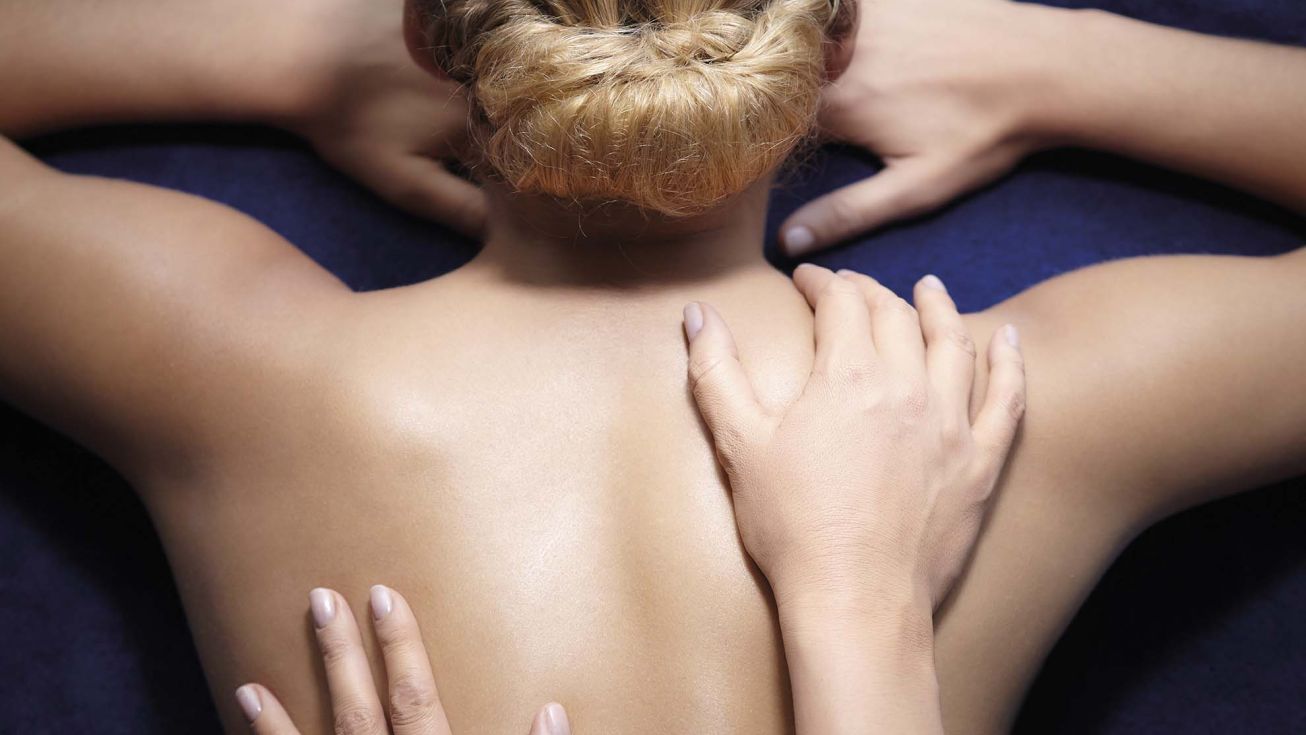 femme se faisant masser le dos durant un soin décontractant et reminéralisant avec les produits phytomer