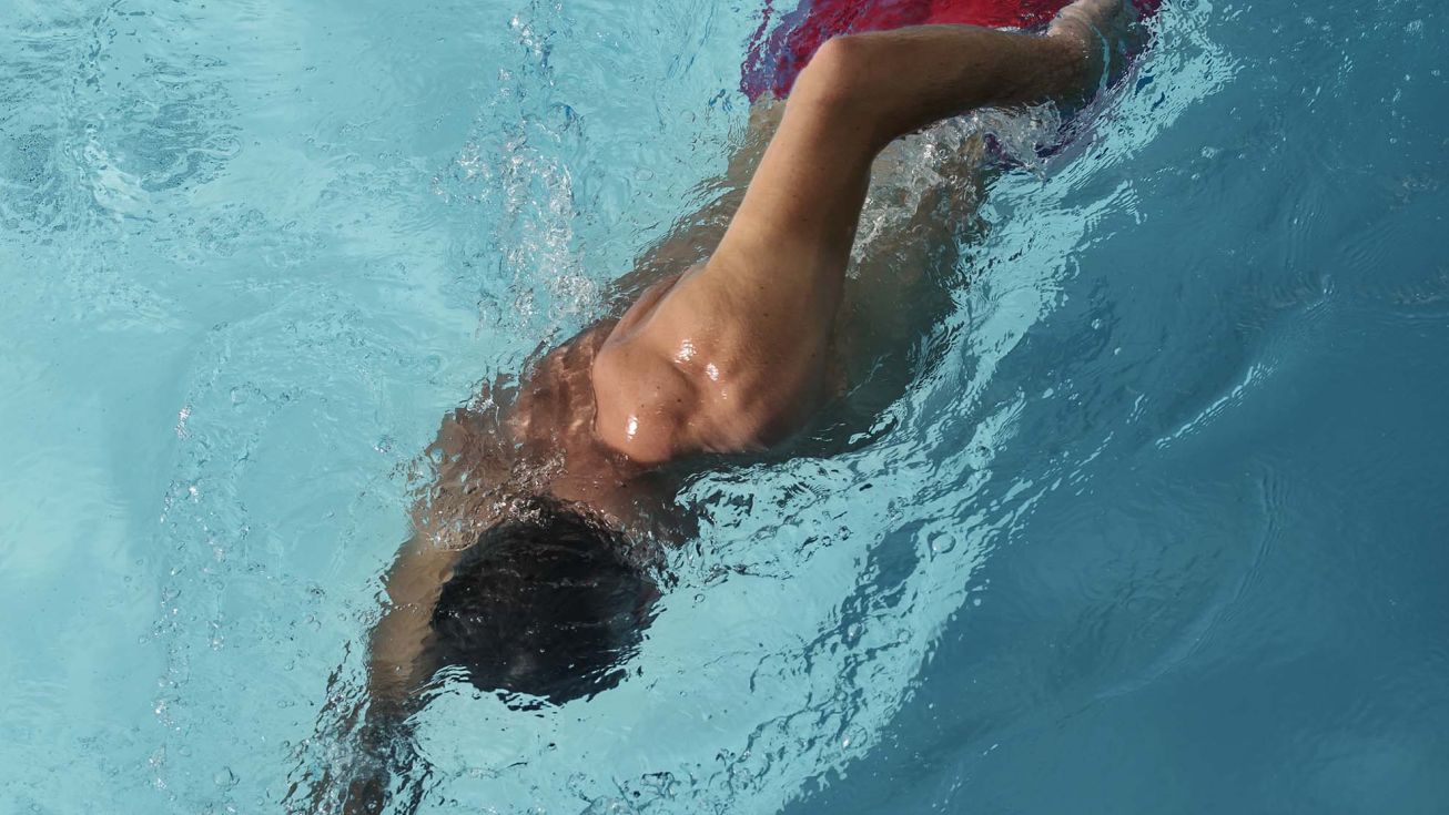 Homme qui nage dans une piscine
