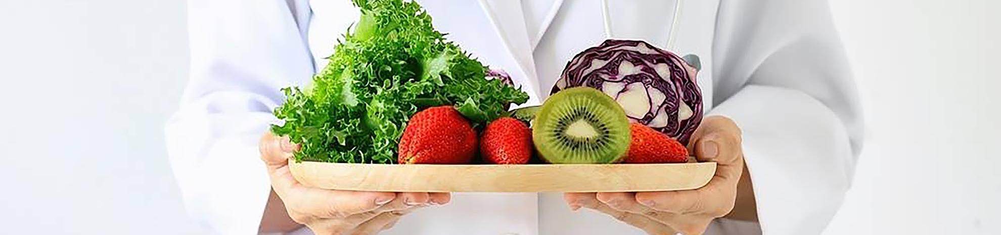 Nutritionniste avec un plateau de fruits et légumes dans les mains