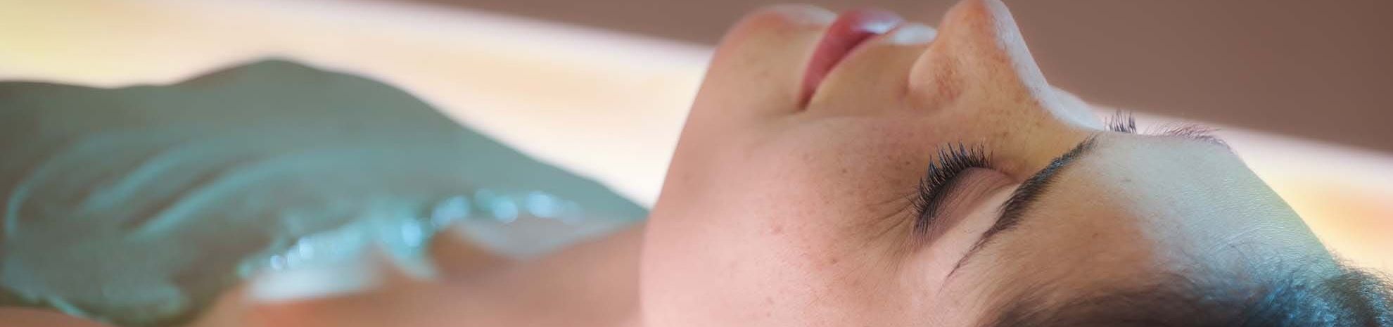 Femme recevant un soin d'enveloppement thermo-actif aux algues sur lit hydrosensoriel