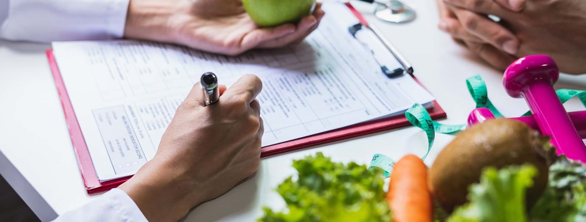 Main d'une personne réalisant une consultation diététique