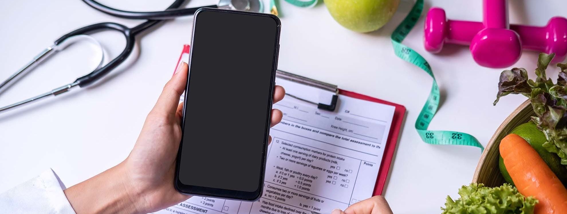 Main d'une personne qui tient un téléphone pour les consultations externes et téléphoniques